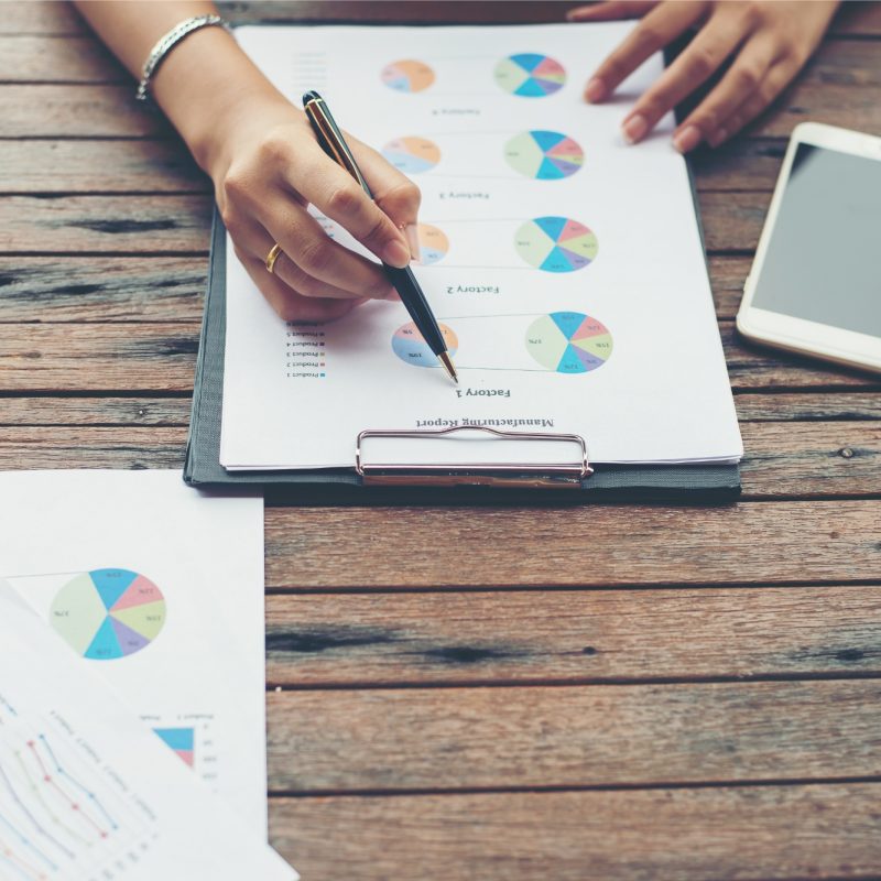 La joven mujer de negocios entrega análisis con gráfico de negocios en el lugar de trabajo, realizando asi asesoría empresarial