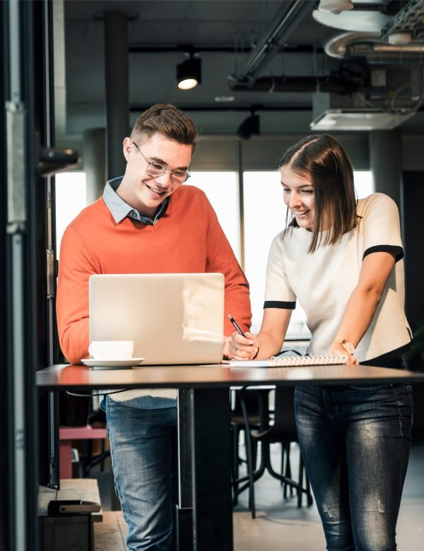 Empresario casual y mujer con laptop reuniéndose en la oficina para realizar asesoría empresarial